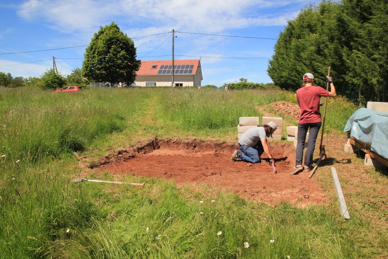 Vérification que le terrain est de niveau pour les fondations de l'abri de jardin